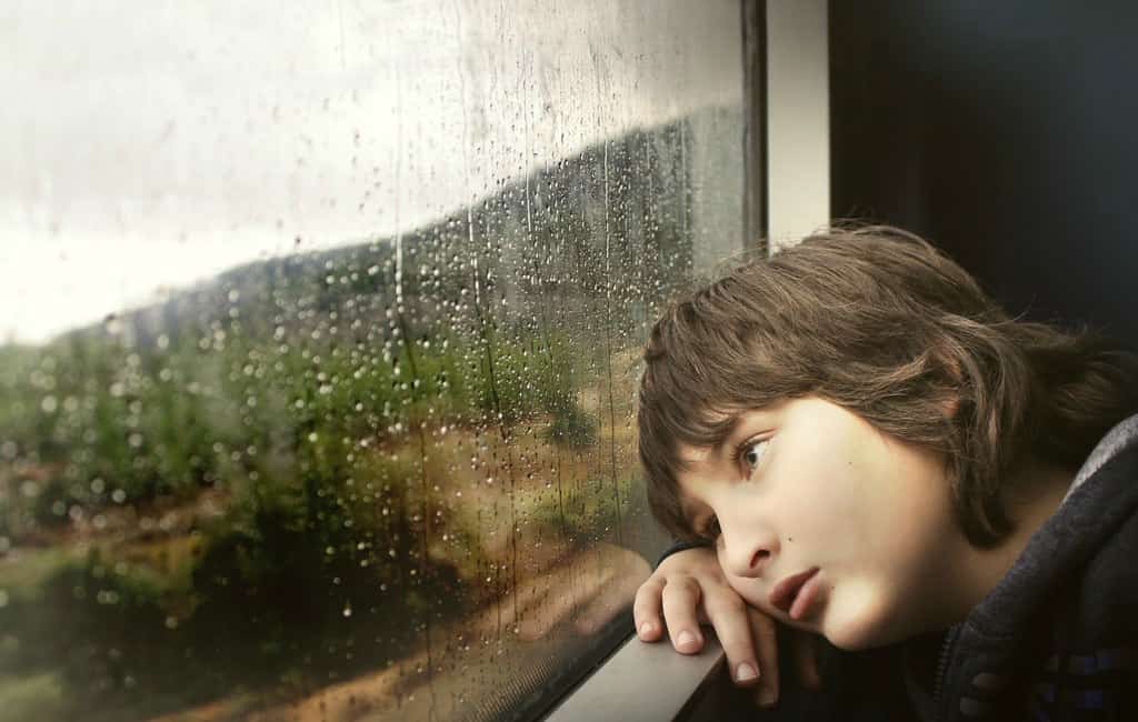 lazy tired boy sitting thinking money window rain drops