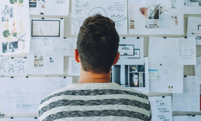 become entrepreneur, man standing and thinking, man standing in front of clipboard