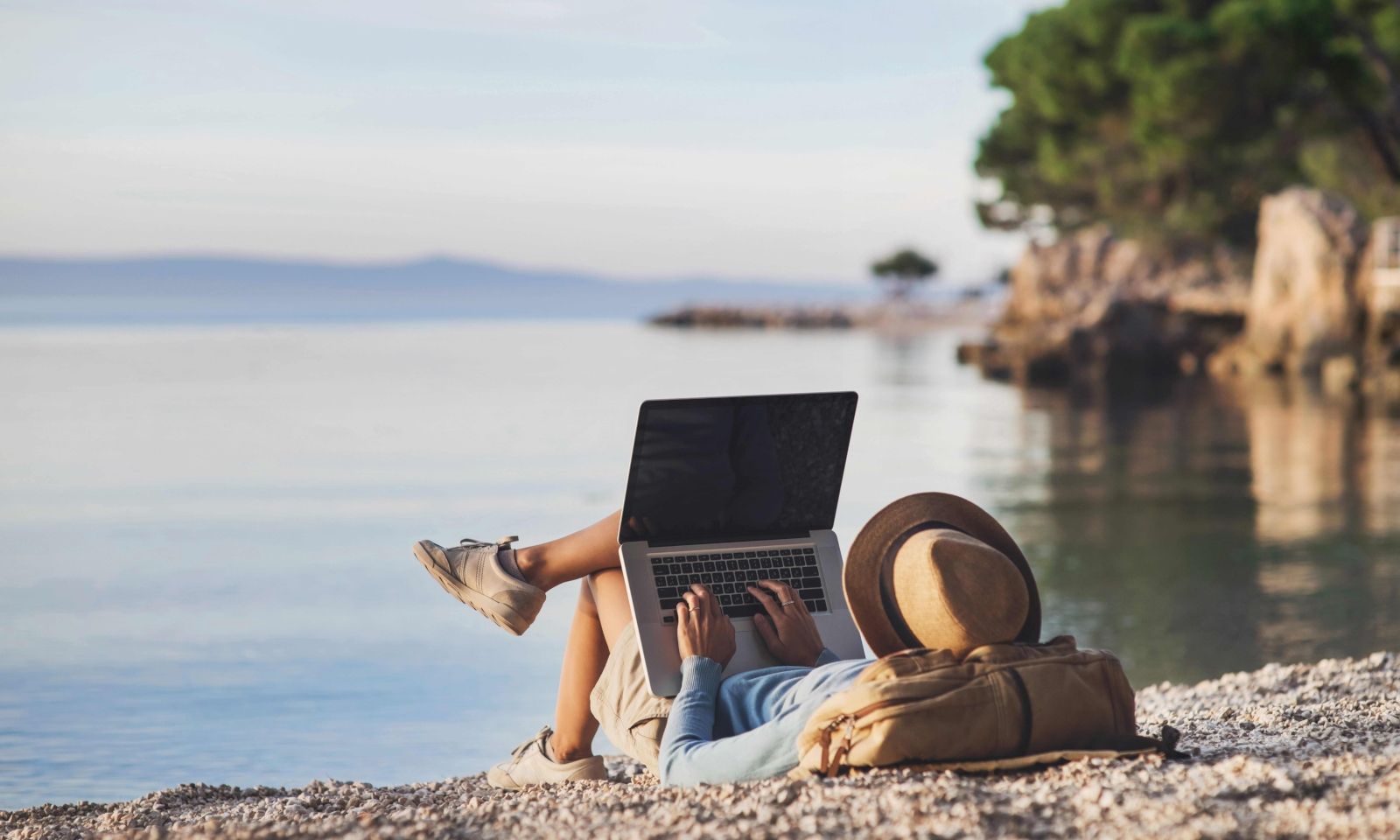 remote employee, man working on beach, man using laptop on beach